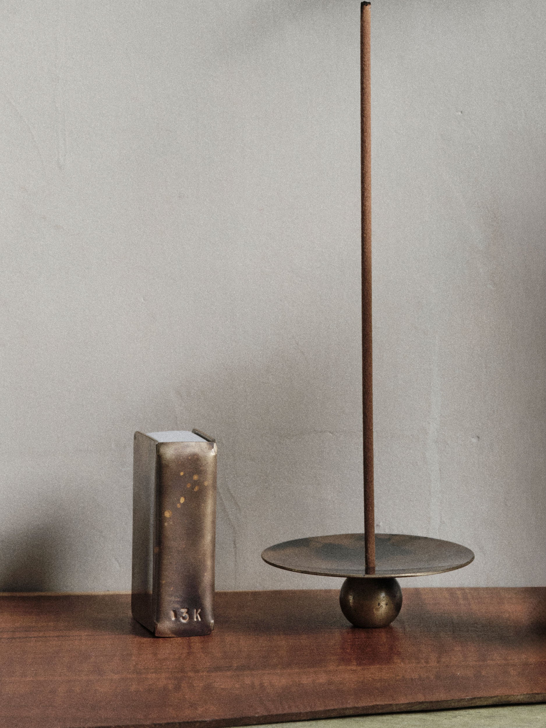 13 Knives handmade brass matchbox holder and brass incense burner set shown on a timber tabletop with a burning incense stick