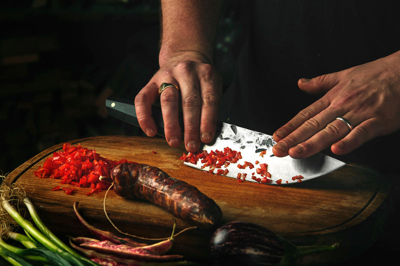 chef using a hand forged high carbon chef knife in kitchen made in melbourne australia by 13 knives